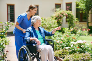 Shot of a resident and a nurse outside in the retirement home garden