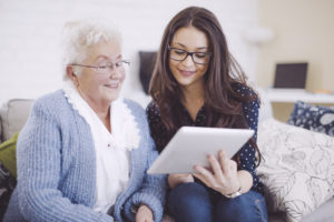 Granddaughter together with her happy grandmother at home