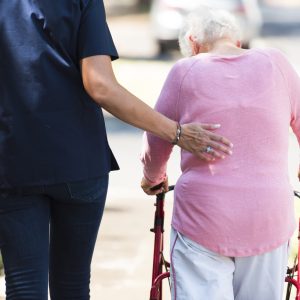 The back of a nurse and a senior lady taking a walk